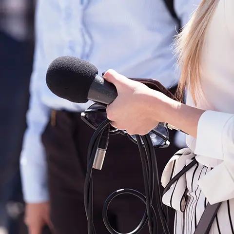 Photo d'une femme tenant un micro lors d'une interview